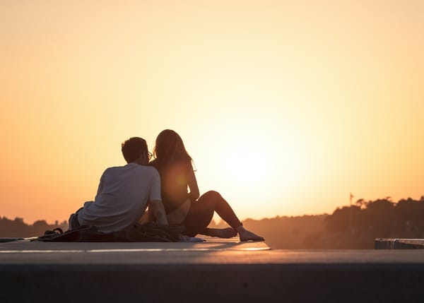 Long distance relationships - couple sitting near trees during golden hour